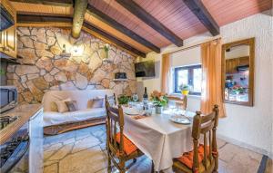 a dining room with a table and a stone wall at Amazing Home In Rovinj With 2 Bedrooms And Outdoor Swimming Pool in Spanidiga