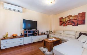 uma sala de estar com um sofá branco e uma televisão de ecrã plano em 3 Bedroom Nice Home In Kostrena em Kostrena