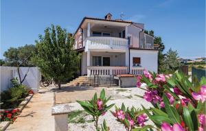 a white house with pink flowers in front of it at 2 Bedroom Gorgeous Apartment In Medulin in Medulin