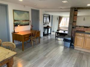 un soggiorno con tavolo e scrivania di woodpecker cottage at frog trotters cottages a Hartpury