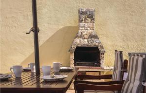 a wooden table with a fireplace in front of a building at Nice Home In Vodice With Kitchen in Vodice