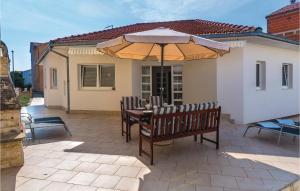 a patio with a table and an umbrella at Nice Home In Vodice With Kitchen in Vodice
