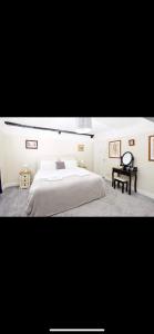 a white bedroom with a bed and a table at The Red Lion in Sedbergh