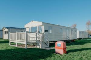 a mobile home with a porch and a staircase at Lakeside, Thorpe Park Cleethorpes Static Caravan in Cleethorpes