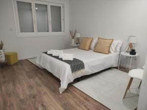 um quarto branco com uma cama e uma janela em Pinheiro Guest House em Ponte de Lima