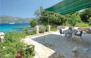 a white dog sitting next to a table and chairs at Amazing Home In Korcula With 1 Bedrooms And Wifi in Korčula