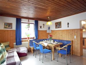 jadalnia ze stołem i niebieskimi krzesłami w obiekcie Sunny holiday flat with balcony w mieście Wagrain