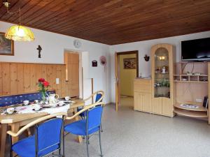 eine Küche und ein Esszimmer mit einem Tisch und blauen Stühlen in der Unterkunft Sunny holiday flat with balcony in Wagrain