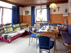 salon ze stołem, krzesłami i kanapą w obiekcie Sunny holiday flat with balcony w mieście Wagrain