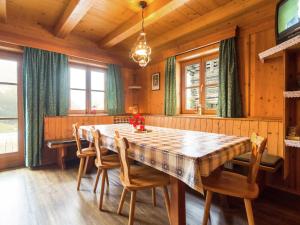 jadalnia z drewnianym stołem i krzesłami w obiekcie Cozy Chalet with Sauna in Gro arl w mieście Grossarl