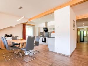 eine Küche und ein Esszimmer mit einem Holztisch und Stühlen in der Unterkunft Apartment directly on the Weissensee in Carinthia in Weissensee