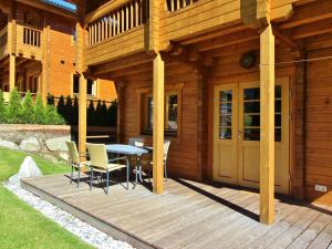 クリムルにあるWooden Chalet in Krimml Salzburg with garden grillの木製デッキ(テーブル、椅子付)