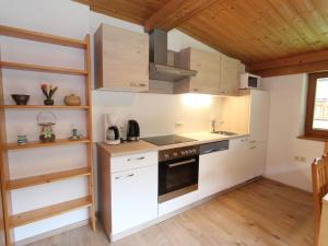 a kitchen with white appliances and a wooden ceiling at Apartment near the ski area in Saalbach Hinterglemm