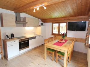 a kitchen and dining room with a wooden table and chairs at Apartment near the ski area in Saalbach Hinterglemm