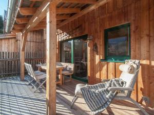 a wooden deck with a table and chairs on it at Chalet in Stadl an der Mur Styria with sauna in Stadl an der Mur
