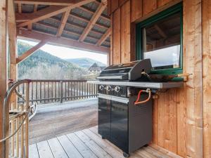 a grill on the deck of a cabin with a balcony at Chalet in Stadl an der Mur Styria with sauna in Stadl an der Mur