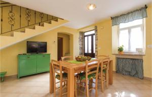 a dining room with a table and a green cabinet at Gorgeous Home In Burjaki With Kitchen in Trgetari