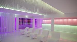 a room with a row of white chairs and purple lights at So Nice Club Resort in Ayia Napa