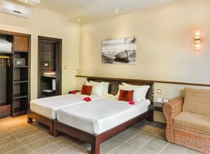 a bedroom with a large bed and a couch at Dodola Lodge in Pereybere