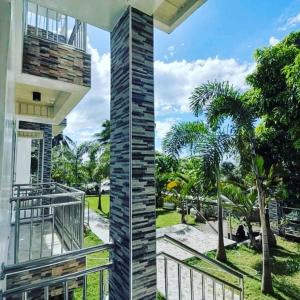 einen Balkon eines Hauses mit einem Zaun und Palmen in der Unterkunft Marlene's Hilltop Villa in Cebu City