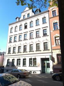 un gran edificio blanco al lado de una calle en Ferienwohnungen in der Kunstgalerie Charlie und Jenny, en Chemnitz