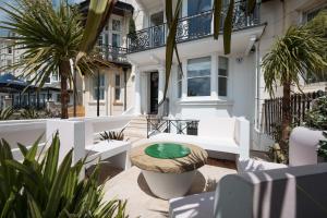 ブライトン＆ホーブにあるEastcliff House & The Art Deco Flatの家の前にテーブルと椅子が置かれたパティオ