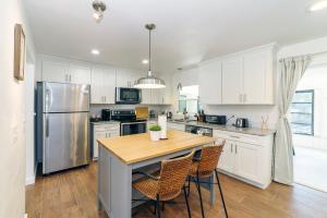 a kitchen with white cabinets and a table with chairs at NEW Cozy House 5 Min Three Sisters Springs in Crystal River