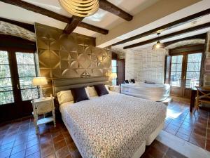 Akla La Casa Del Puente في Regules: غرفة نوم مع سرير وحوض استحمام