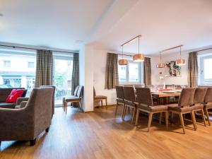 a dining room and living room with a table and chairs at Chalet in Bruck Gro glocknerstrasse with sauna in Bruck an der Großglocknerstraße