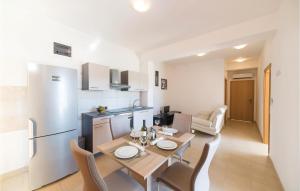 eine Küche und ein Esszimmer mit einem Tisch und Stühlen in der Unterkunft Lovely Apartment In Divulje With Outdoor Swimming Pool in Djvulje