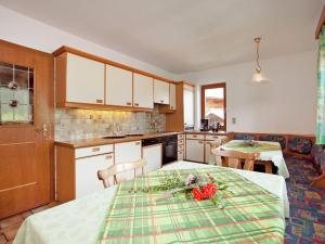 eine Küche mit einem Tisch mit Blumen darauf in der Unterkunft Beautiful apartment in Fugen Zillertal in Fügen