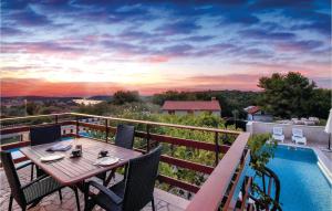 een patio met een tafel en stoelen naast een zwembad bij 4 Bedroom Beautiful Home In Pula in Pula