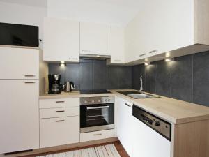 a kitchen with white cabinets and a sink at Modern Apartment in F genberg with Garden in Fügenberg