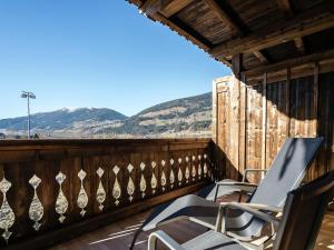 a pair of chairs on a balcony with mountains in the background at Apartment in Hollersbach with sauna near ski area in Hollersbach im Pinzgau