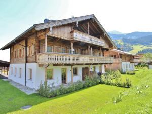 a large wooden house on a hill with a yard at Apartment in Hollersbach with sauna near ski area in Hollersbach im Pinzgau
