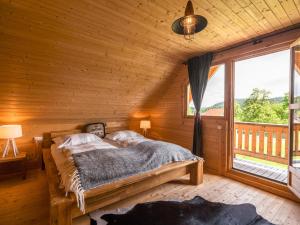 a bedroom with a bed and a large window at Chalet in Finkenstein Carinthia on Lake Faak in Ledenitzen