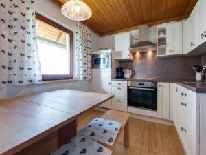 EbersteinにあるHoliday home in Eberstein near Woertherseeの白いキャビネットと木製の天井が備わるキッチン