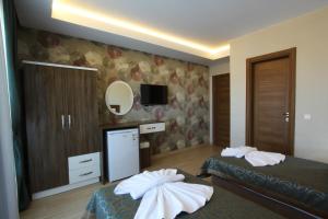 a hotel room with two beds and a mirror at Inciler Hotel in Altınoluk