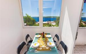 a table with chairs in a room with a window at Beautiful Apartment In Crikvenica With Kitchen in Crikvenica