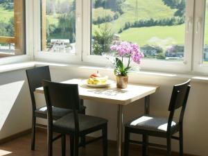 una mesa y sillas con un bol de frutas y flores. en Apartment with terrace in Kaprun Salzburg, en Kaprun