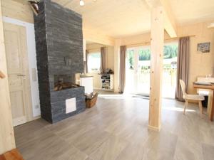 ein großes Wohnzimmer mit einem Steinkamin in der Unterkunft Wooden chalet in Hohentauern with sauna in Hohentauern