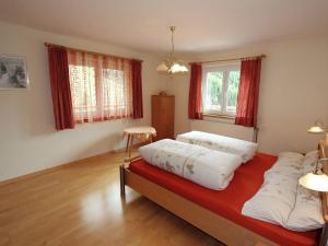 a bedroom with a bed with white pillows on it at Home with a wooden decor and full of atmosphere in Außervillgraten