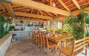 an outdoor kitchen with a wooden table and chairs at Nice Apartment In Mravince With 2 Bedrooms, Wifi And Outdoor Swimming Pool in Mravince