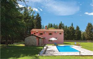 une maison rose avec une piscine en face de celle-ci dans l'établissement Stunning Home In Vrsar With Kitchen, à Vrsar