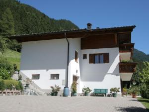 ein weißes Gebäude mit einem Hügel im Hintergrund in der Unterkunft Apartment in Montafon near the ski area in Sankt Gallenkirch