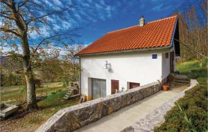 une maison blanche avec un toit orange et un mur en pierre dans l'établissement Awesome Apartment In Stolac With House A Panoramic View, à Žukalj