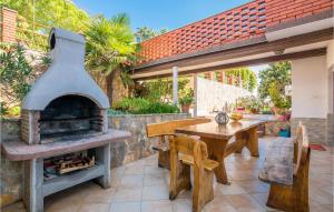 a outdoor patio with a fireplace and a table and chairs at 3 Bedroom Nice Apartment In Krk in Krk