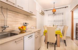 a kitchen with a sink and a table with a bowl of fruit at 3 Bedroom Nice Apartment In Krk in Krk
