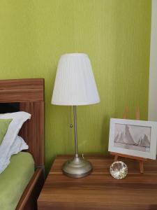 una lampada seduta su un tavolo accanto a un letto di Casa-Maria a Ehrenberg