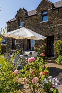 a table and chairs with an umbrella in front of a building at Seascape B&B in Union Hall